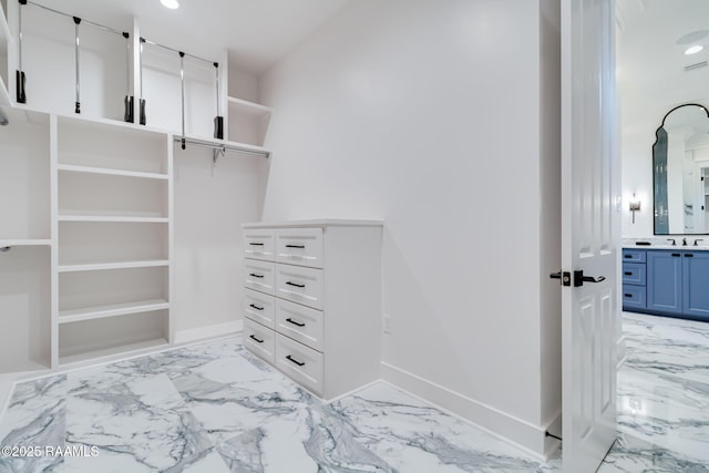spacious closet with marble finish floor and a sink