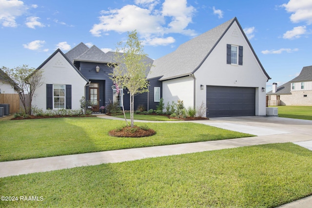 view of front of house featuring central AC unit, a garage, and a front lawn