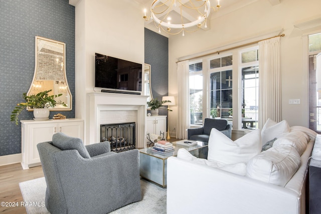 living room with ornamental molding, light hardwood / wood-style flooring, and a notable chandelier