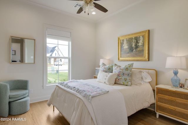 bedroom featuring hardwood / wood-style floors, ceiling fan, and multiple windows