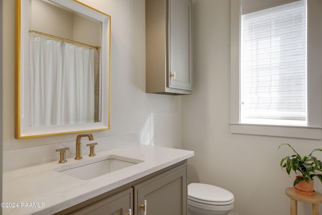 bathroom with vanity, curtained shower, and toilet