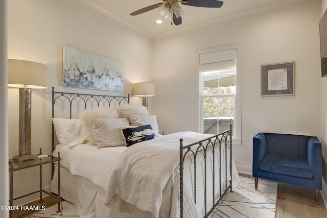 bedroom featuring ceiling fan, crown molding, and light wood-type flooring