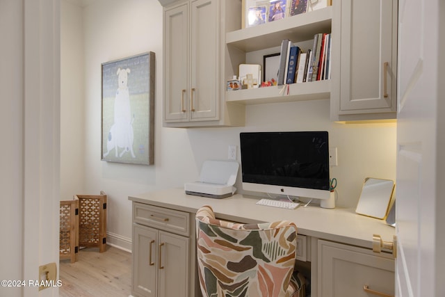 office space featuring light wood-type flooring and built in desk