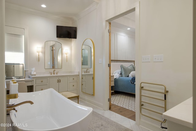 bathroom with a washtub, hardwood / wood-style floors, vanity, and crown molding