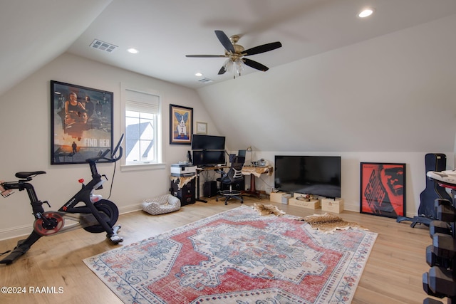 exercise area with ceiling fan, light hardwood / wood-style flooring, and lofted ceiling