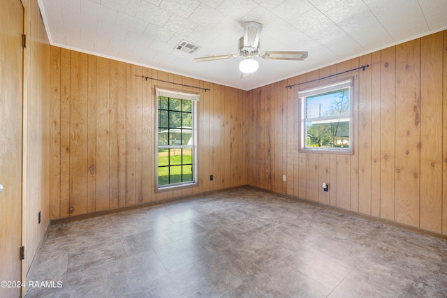 spare room featuring wood walls and ceiling fan