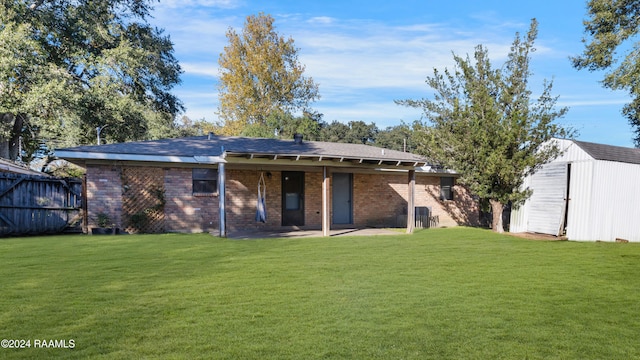 rear view of house featuring a patio area, a shed, and a yard