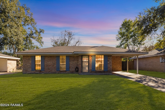 ranch-style home with a lawn and a carport