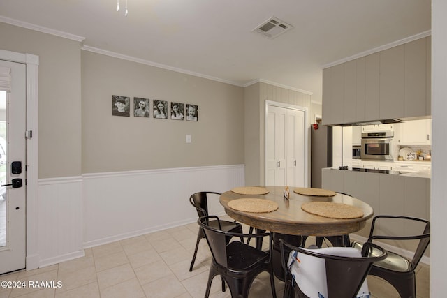 dining area with crown molding and light tile patterned flooring