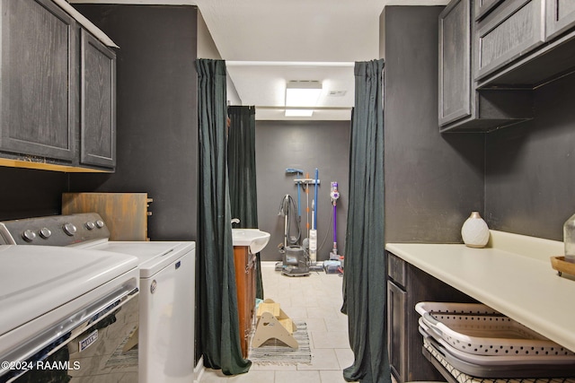 washroom with cabinets, light tile patterned floors, and washing machine and dryer