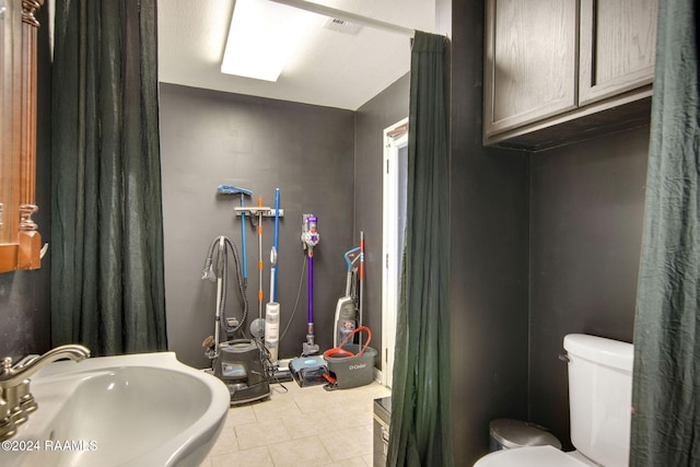 bathroom with tile patterned flooring, toilet, and sink