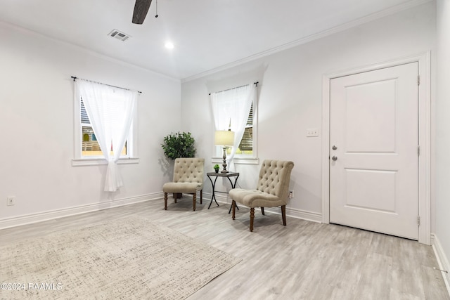 sitting room with light hardwood / wood-style flooring and crown molding