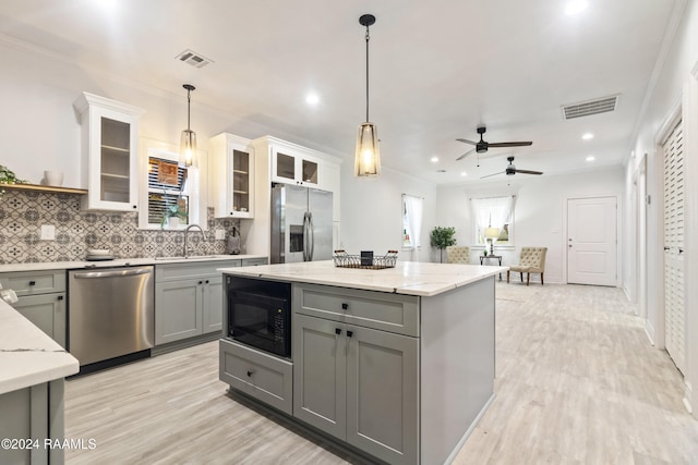 kitchen with gray cabinetry, pendant lighting, sink, appliances with stainless steel finishes, and tasteful backsplash