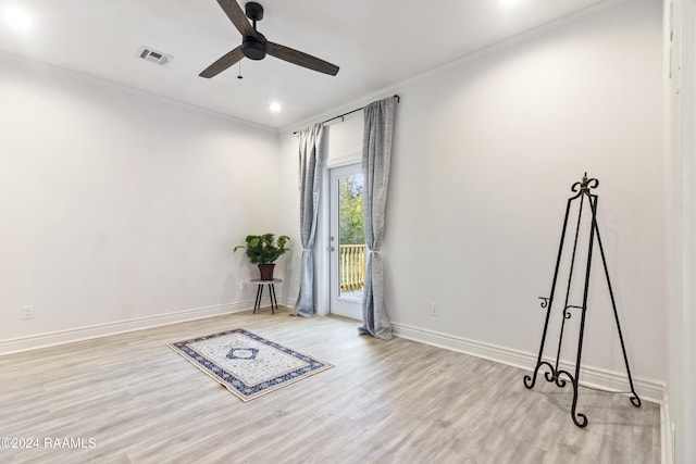 unfurnished room featuring ceiling fan, ornamental molding, and light wood-type flooring