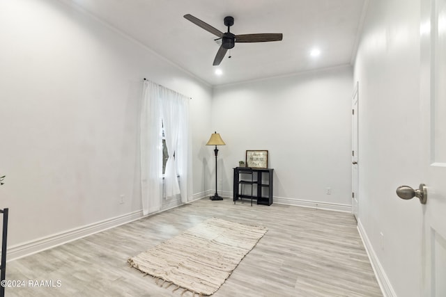 spare room featuring ceiling fan, ornamental molding, and light wood-type flooring