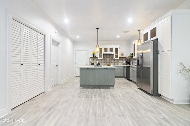 kitchen with gray cabinetry, light hardwood / wood-style flooring, appliances with stainless steel finishes, decorative light fixtures, and a kitchen island