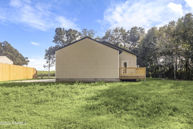 view of side of home with a yard and a deck