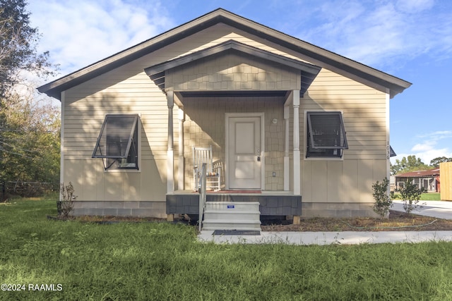 bungalow-style home with a front yard