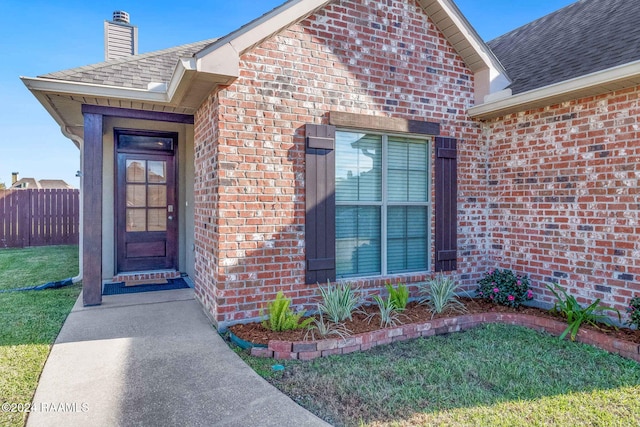 view of exterior entry with a yard