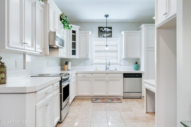 kitchen with pendant lighting, sink, light tile patterned flooring, white cabinetry, and stainless steel appliances