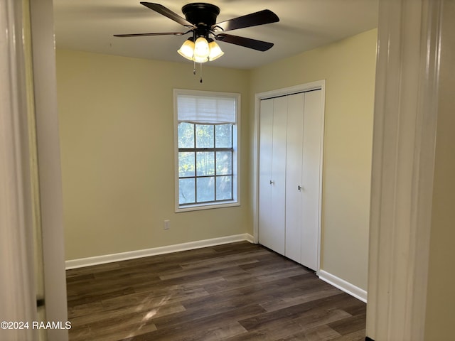 unfurnished bedroom with a closet, ceiling fan, and dark wood-type flooring