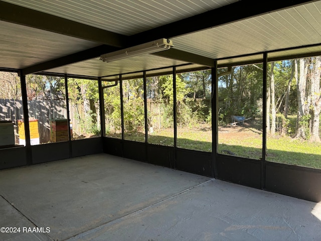 unfurnished sunroom with beamed ceiling