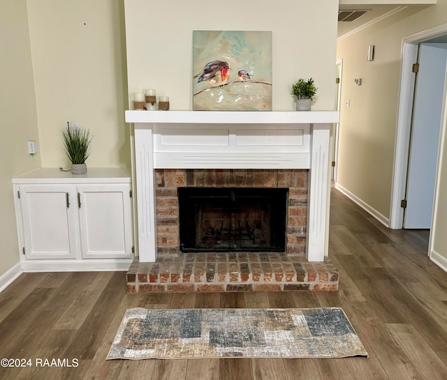 room details with hardwood / wood-style flooring, crown molding, and a brick fireplace