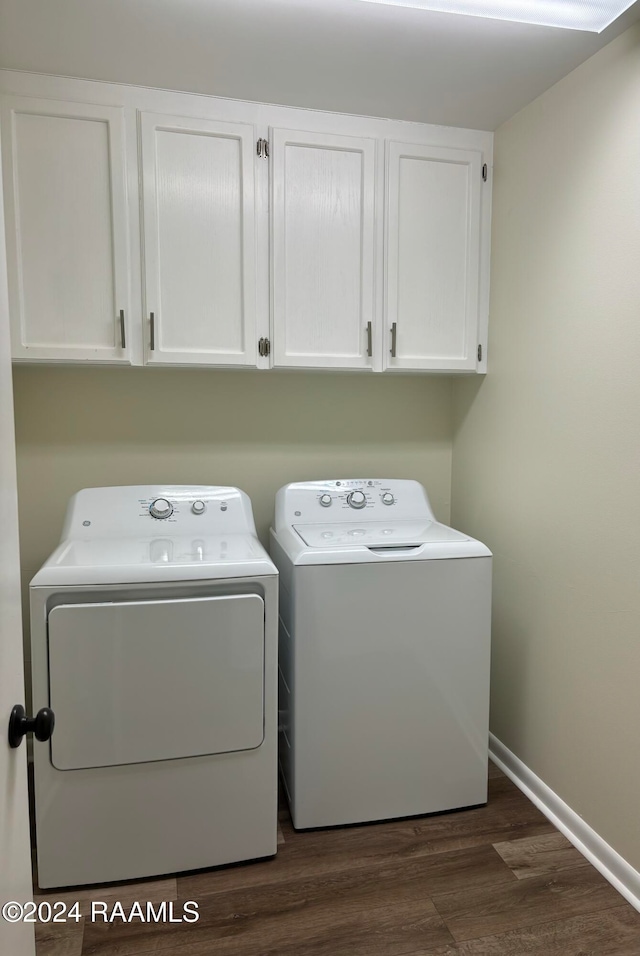 laundry room with washer and dryer, cabinets, and dark wood-type flooring