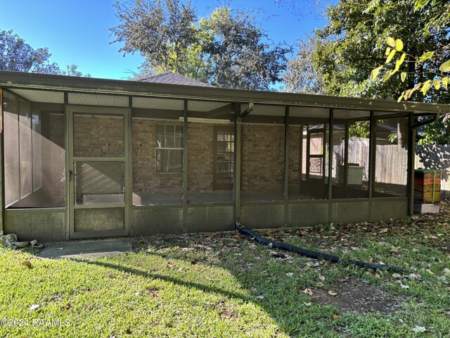 141 Hummingbird Ln, Lafayette, LA 70506 - rear view of property featuring a sunroom, brick siding, and a yard