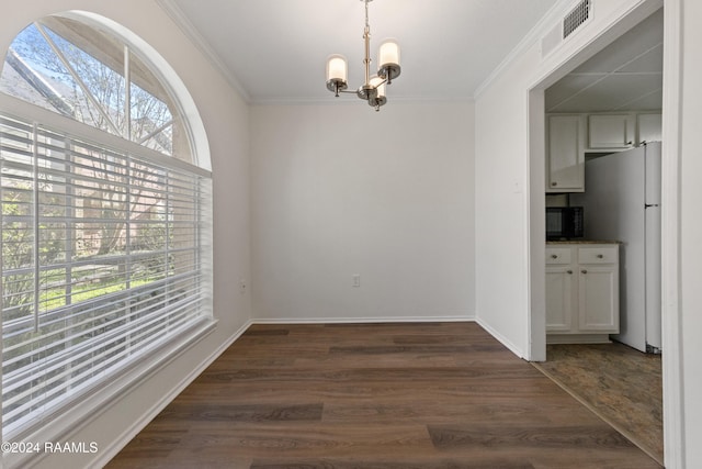 unfurnished dining area with a notable chandelier, dark hardwood / wood-style flooring, and ornamental molding