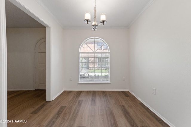 unfurnished room with a chandelier, ornamental molding, and dark wood-type flooring