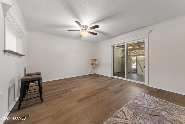 living room with dark hardwood / wood-style floors, ceiling fan, crown molding, and a textured ceiling