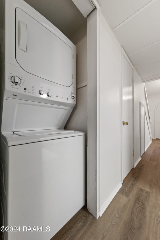 washroom with stacked washer and dryer and dark hardwood / wood-style floors