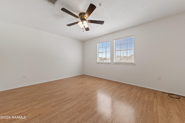 unfurnished room with ceiling fan, light hardwood / wood-style floors, and a textured ceiling