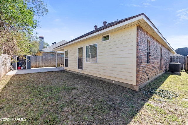 back of property with cooling unit, a lawn, and a patio