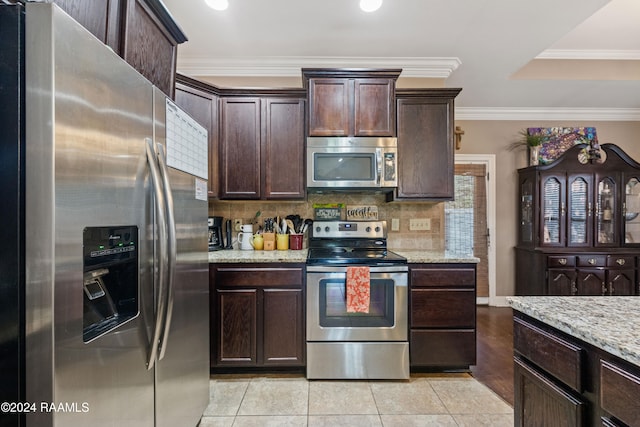 kitchen featuring dark brown cabinetry, light stone counters, stainless steel appliances, and ornamental molding