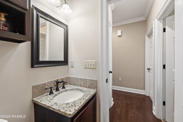 bathroom with crown molding, vanity, and wood-type flooring