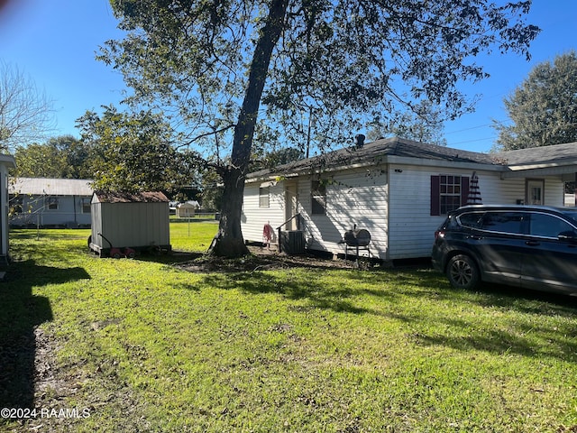 view of side of property featuring a lawn, a storage unit, and an outdoor structure