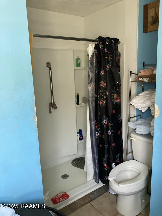 full bathroom with a shower stall, toilet, and tile patterned floors