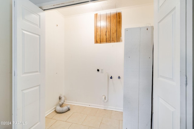 washroom with hookup for an electric dryer, light tile patterned floors, and crown molding