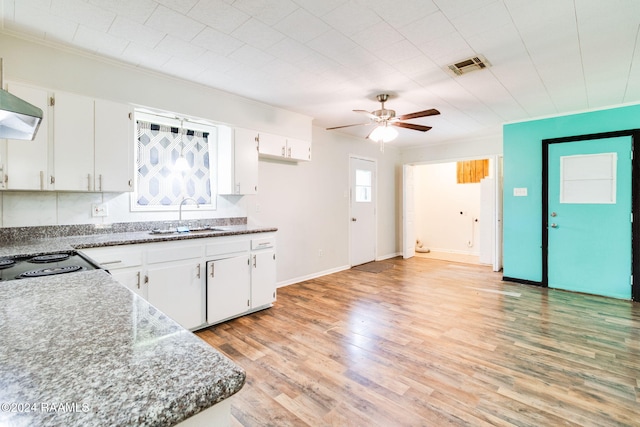 kitchen with light wood-type flooring, white cabinetry, and sink