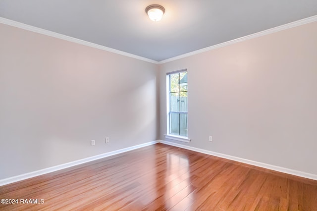 spare room featuring crown molding and wood-type flooring