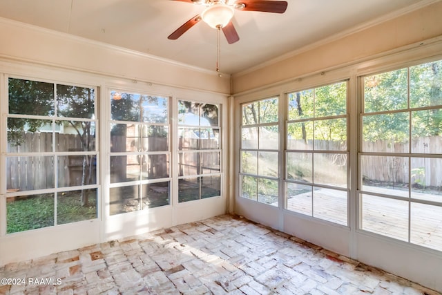 unfurnished sunroom with ceiling fan and a healthy amount of sunlight