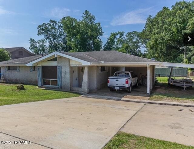 436 E Pont Des Mouton Rd, Lafayette, LA 70507 - ranch-style house featuring a front lawn, a carport, brick siding, and concrete driveway