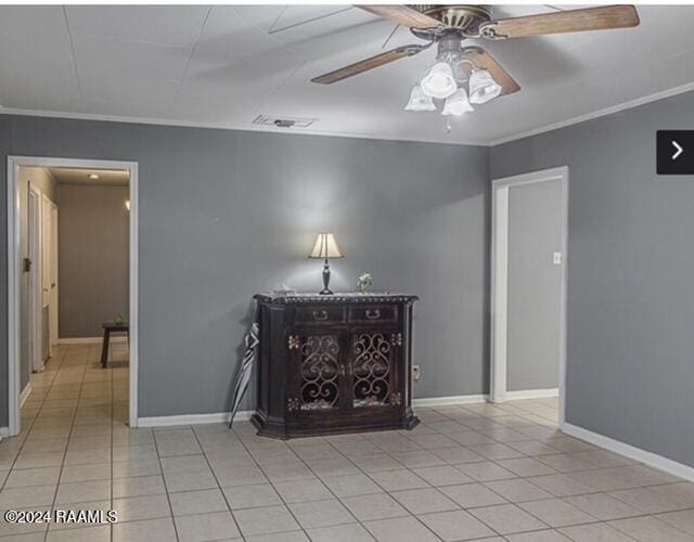 unfurnished room featuring ceiling fan, ornamental molding, and light tile patterned floors