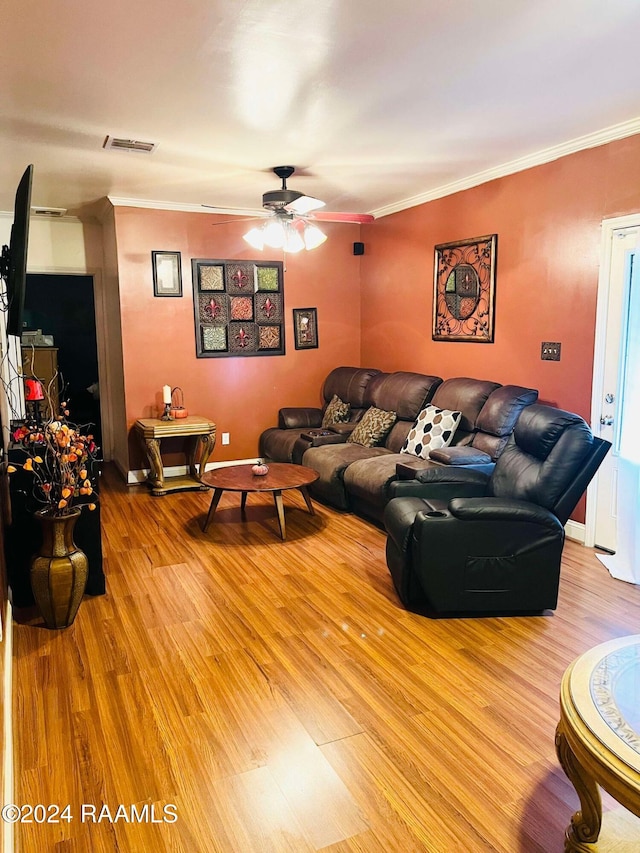 living room featuring light hardwood / wood-style floors, ceiling fan, and crown molding