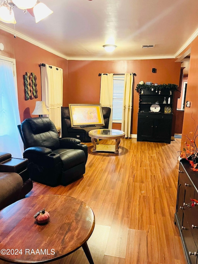 living room featuring ornamental molding and light hardwood / wood-style flooring