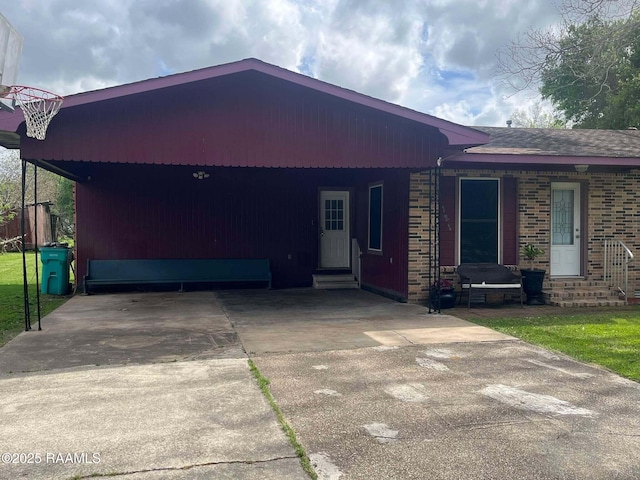 ranch-style home with entry steps, an attached carport, and driveway