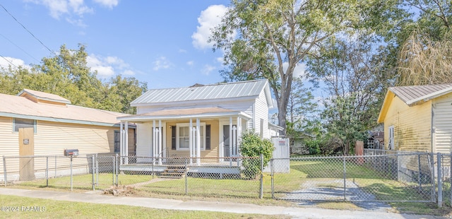 bungalow featuring covered porch and a front yard