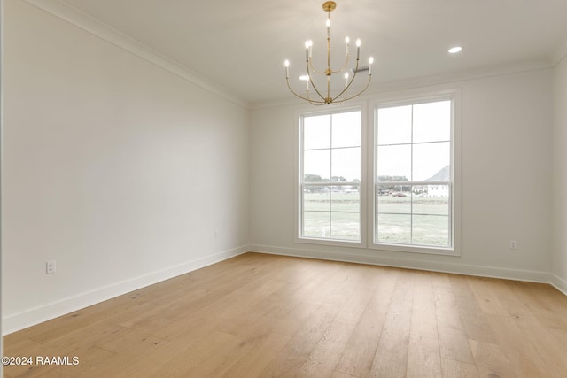 empty room featuring light hardwood / wood-style floors, ornamental molding, and a chandelier